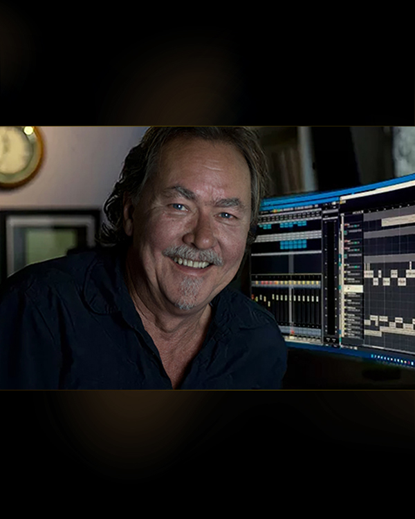 Jeff Watkinson at the desk in the YES AUDIO control room, smiling, multitrack session on the monitors behind him